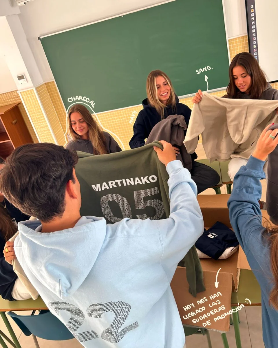 Alumnos de Bachillerato revisando las sudaderas personalizadas de su promoción