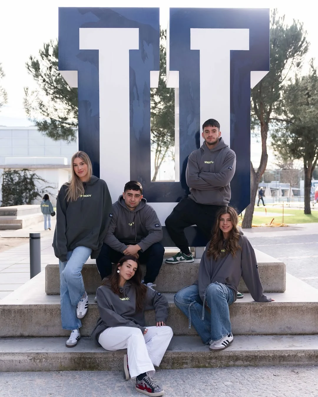 Grupo universitario con sudaderas personalizadas en el campus
